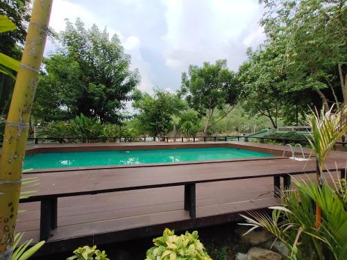 a swimming pool in the middle of a garden at Mamaungpaa Hill resort in Ta Khli
