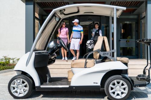 three people standing in the back of a white golf cart at Dreamland Golf Hotel Baku in Baku