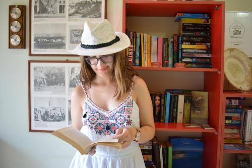 a woman wearing a cowboy hat reading a book at Melina's House in Stalos