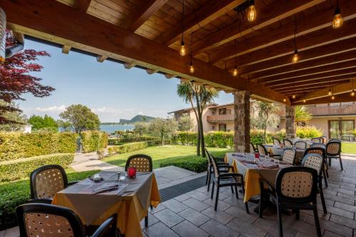 a patio with tables and chairs with a view at Onda Blu Resort in Manerba del Garda