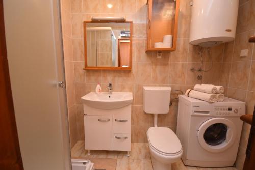 a bathroom with a toilet sink and a washing machine at Apartman Zoran in Herceg-Novi