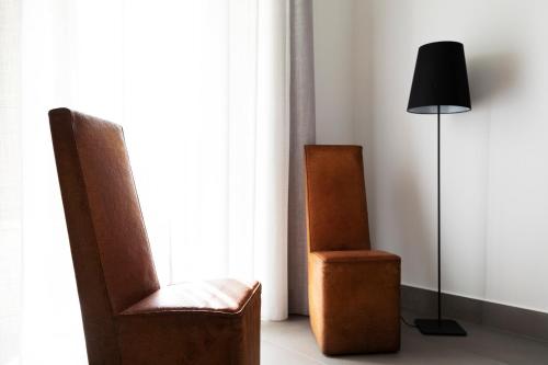 a room with two chairs and a lamp and a window at Acate81 Lifestyle Apartment in Naples