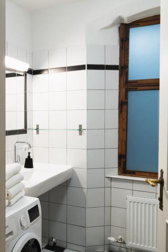 a white bathroom with a sink and a window at Apartments Golden Roof by Penz in Innsbruck