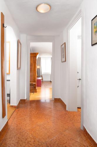 an empty hallway with white walls and a tile floor at Apartments Golden Roof by Penz in Innsbruck