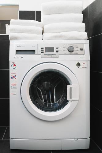 a white washing machine with towels on top of it at Apartments Golden Roof by Penz in Innsbruck