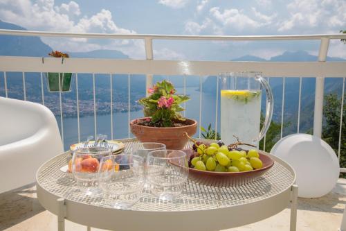 a table with a bowl of fruit on a balcony at Villa Ponti Bellavista in Bellagio