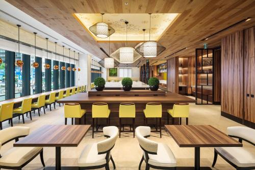 a large dining room with tables and yellow chairs at Hotel Monterey Le Frere Osaka in Osaka