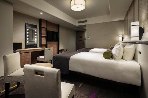 a hotel room with a large bed and a desk at Hotel Monterey Le Frere Osaka in Osaka