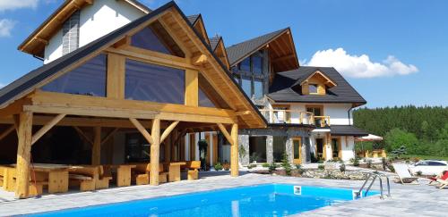 a house with a pool in front of it at Willa Zaolzie in Istebna