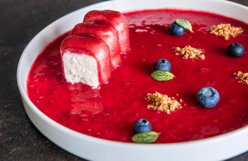 a dessert with a piece of fruit and blueberry sauce at matill - timeless boutique retreat in Laces
