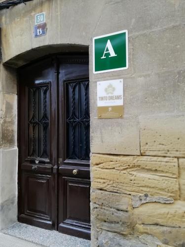 a large wooden door with a sign in front of it at Tinto Dreams Hostel in Haro