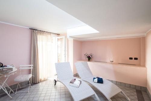 a living room with white chairs and a table at Residenza Santa Cecilia in San Vincenzo