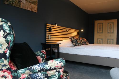 ein Schlafzimmer mit einem Bett und einem Stuhl neben einem Bett in der Unterkunft Hotel Restaurant De Roosterhoeve in Roosteren