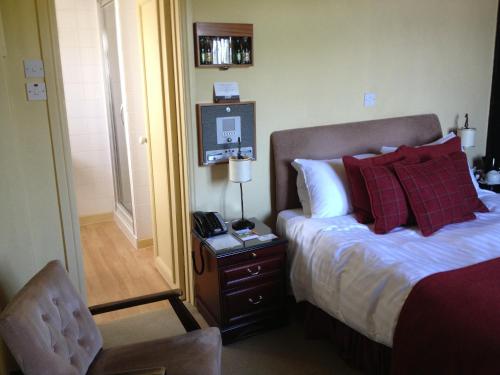 a bedroom with a bed and a table with a phone at The Rock Inn in Bovey Tracey