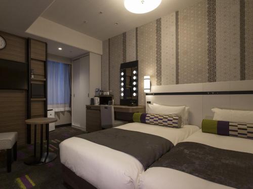 a hotel room with two beds and a kitchen at Hotel Monterey Le Frere Osaka in Osaka