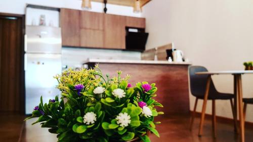 un vase de fleurs assis sur une table dans une cuisine dans l'établissement Sunny Mountain House, à Kazbegi