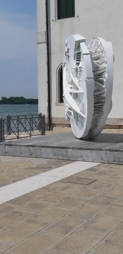a white sculpture sitting on a sidewalk next to a building at Isola di San Servolo - Centro Soggiorno in Venice