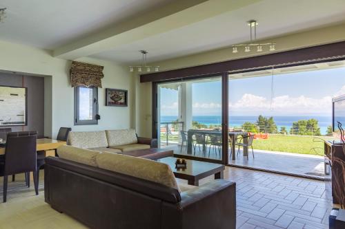 a living room with a view of the ocean at Villa Rossa in Hanioti