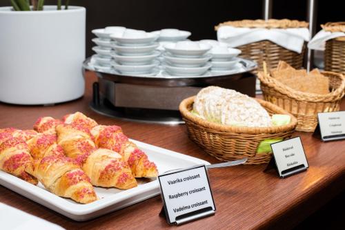 a table with a plate of pastries and baskets of bread at Pärnu Hotel in Pärnu