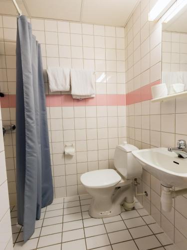 a bathroom with a toilet and a sink at Strand Hotell Sortland in Sortland