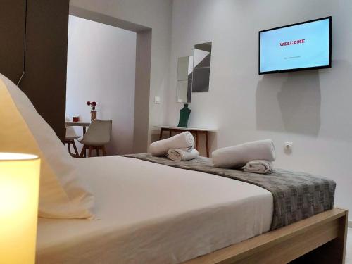 a bedroom with a bed with a flat screen tv on the wall at Neva Apartments by the Beach in Makry Gialos