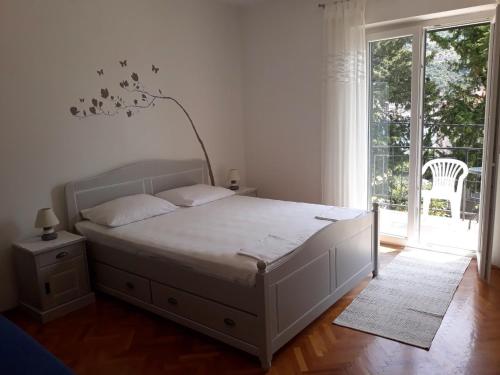 a bedroom with a bed and a large window at Rooms Sentic in Dubrovnik