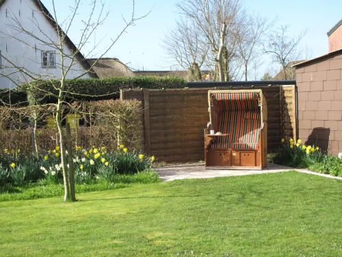 a wooden gate in a garden with a fence at Haus-an-de-Marsch in Midlum