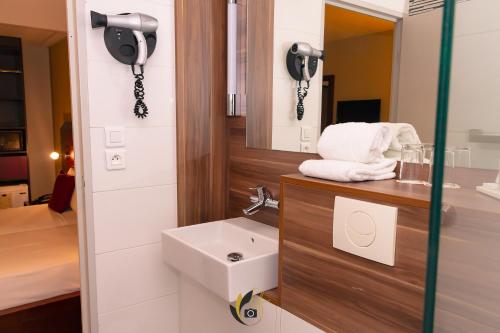 La salle de bains est pourvue d'un lavabo et d'un miroir. dans l'établissement Tulip inn Sainte Clotilde, à Saint-Denis
