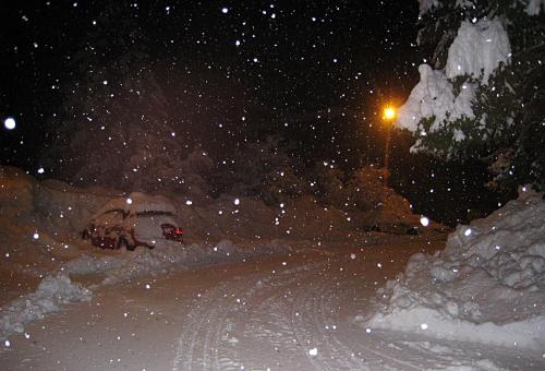 a street covered in snow at night with a street light at Gästehaus Steiner in Tröpolach