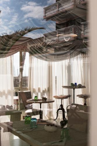 a living room with tables and a large window at Residenza Santa Cecilia in San Vincenzo