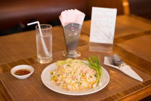 a table with a plate of food and a glass of water at Siam Palace Hotel in Bangkok