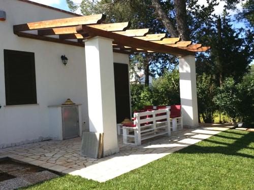 a pergola with a table and chairs in a yard at Villa del Sole in Manduria