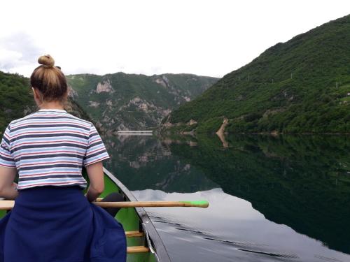 a woman in a row boat on a river at Apartment Relax in Pluzine