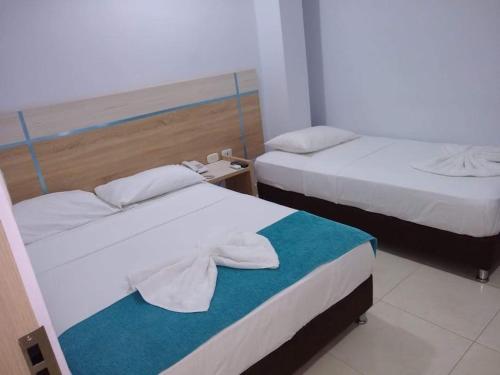 two beds in a hotel room with towels on them at Hotel SGH Boutique Deluxe in Santa Marta