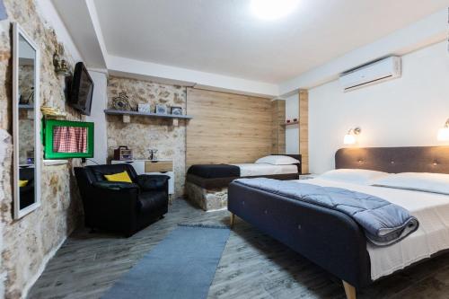a hotel room with two beds and a chair at S&A 3BR Holiday Home in Bibinje