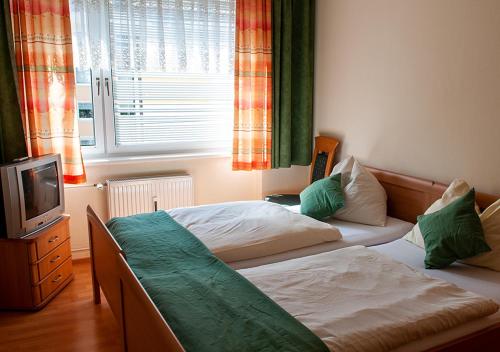 1 Schlafzimmer mit 2 Einzelbetten und einem TV in der Unterkunft Apartment am Bahnhof in Salzburg