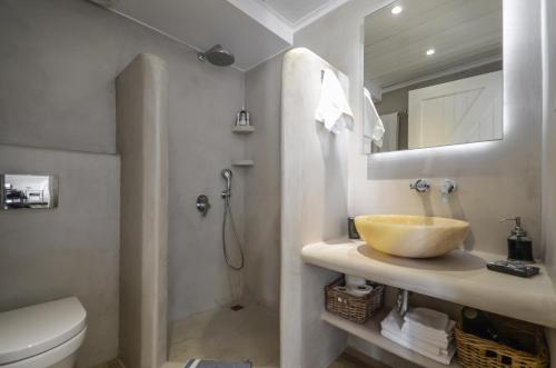 a bathroom with a sink and a toilet and a mirror at Naxos Rock Villas in Stelida