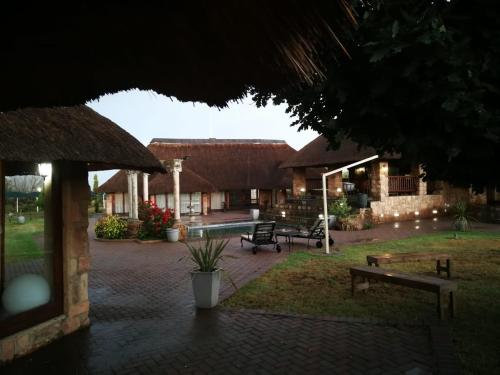a courtyard of a house with benches and a pavilion at Stone Hounds Lodge in Magaliesburg