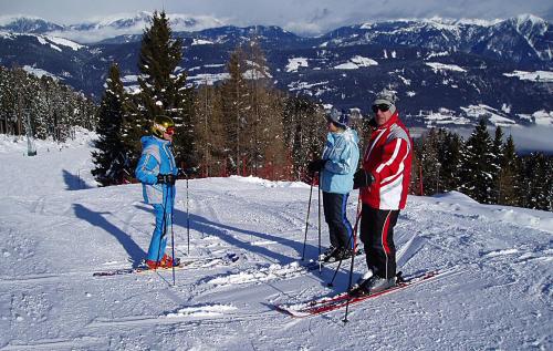 three people standing on top of a ski slope at Gästehaus Steiner in Tröpolach