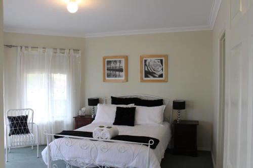 a bedroom with a white bed with black and white pillows at Waterside View in Augusta