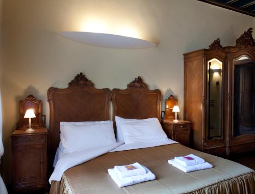 a bedroom with a bed with two towels on it at Hotel Villa Giulia in Gargnano