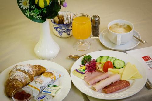 a table with two plates of food and a cup of coffee at Hotel San Pietro in Limone sul Garda