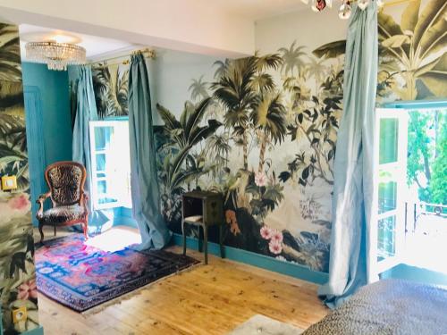 a living room with a mural of plants on the wall at La Rebière d'Or, B&B et Gîte in Mouleydier