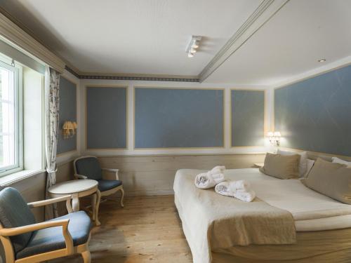 a bedroom with a bed with towels on it at Åkerblads Hotell Gästgiveri Spa in Tällberg