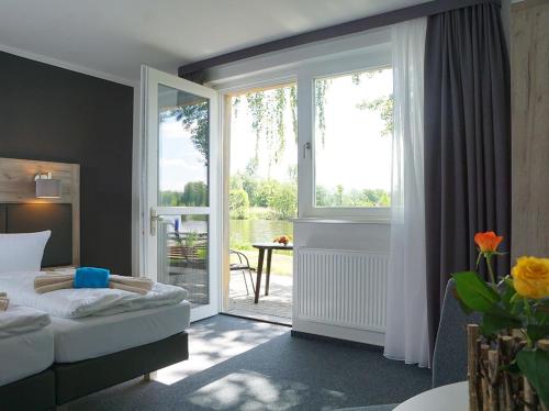 a bedroom with a bed and a sliding glass door at Boootshaus - Am Spreeufer in Beeskow