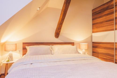a bedroom with a large white bed with two lamps at SKOL apartments in Celje