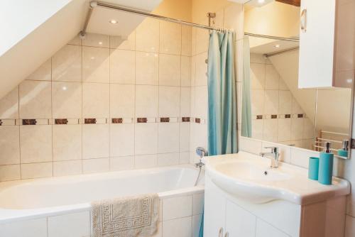 a bathroom with a sink and a bath tub at SKOL apartments in Celje
