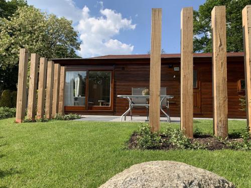 a wooden house with a table in the yard at Bungalowpark Het Verscholen Dorp in Harderwijk