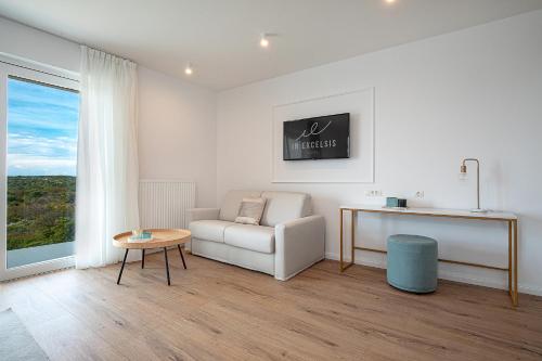 a living room with a white couch and a table at Hotel In Excelsis in Novalja