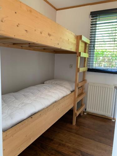 a bunk bed with a ladder in a room at Bungalowpark Het Verscholen Dorp in Harderwijk